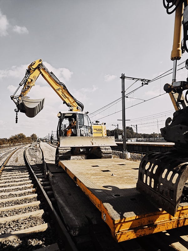 Rupskraan van Van Eerd lost een werktrein tijdens spoorwerkzaamheden aan de metrolijn in Amsterdam